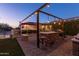 Evening view of backyard oasis with outdoor kitchen and pergola at 509 E Adamanda Ct, Phoenix, AZ 85086