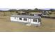 Aerial view of a white manufactured home with gray trim and a large yard at 6326 N Deer Trl, Maricopa, AZ 85139