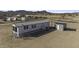 Aerial view of a white manufactured home with gray trim, large yard and desert mountain backdrop at 6326 N Deer Trl, Maricopa, AZ 85139