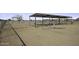 Covered horse pen area with metal fencing surrounded by a sandy lot at 6326 N Deer Trl, Maricopa, AZ 85139