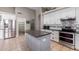 Modern kitchen with island, stainless steel appliances, and white cabinets at 6381 W Kristal Way, Glendale, AZ 85308