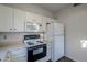 Bright kitchen features white cabinetry, microwave, oven, and refrigerator at 6920 E 4Th St # 105, Scottsdale, AZ 85251