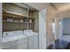 Laundry room with washer, dryer, and shelving for storage at 6920 E 4Th St # 105, Scottsdale, AZ 85251