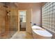 Bathroom with walk-in shower, soaking tub and glass block window at 9353 N 113Th Way, Scottsdale, AZ 85259