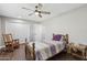 Well-lit bedroom with wood floors, ceiling fan, and a wooden bed frame at 9425 W Sandstone Dr, Sun City, AZ 85351