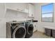 Bright laundry room with washer, dryer, and storage shelves at 9540 E Spiral Ave, Mesa, AZ 85212