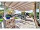 Outdoor kitchen and dining area under pergola at 9825 W Desert Elm Ln, Peoria, AZ 85383