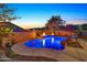 Stunning nighttime view of a sparkling pool and spa at 9825 W Desert Elm Ln, Peoria, AZ 85383