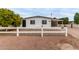 Updated manufactured home with carport and white fence at 1031 S 98Th St, Mesa, AZ 85208