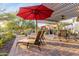 Landscaped backyard oasis with red umbrella and lounge chairs at 1075 W Desert Aster Rd, San Tan Valley, AZ 85143