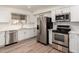 This kitchen features white cabinets, stainless steel appliances, and a tile backsplash, creating a modern and inviting space at 11440 N Hagen Dr, Sun City, AZ 85351