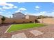 Landscaped backyard with artificial turf and flagstone patio at 11621 W Cheryl Dr, Youngtown, AZ 85363