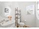 Small bathroom with pedestal sink, toilet, and a stylish shelving unit at 11621 W Cheryl Dr, Youngtown, AZ 85363