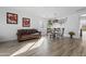 Bright dining area with wood-look floors, leather sofa, and stylish light fixture at 11621 W Cheryl Dr, Youngtown, AZ 85363