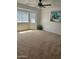 Spacious carpeted main bedroom with large windows and ceiling fan at 11621 W Cheryl Dr, Youngtown, AZ 85363