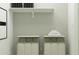 Convenient laundry room with two laundry hampers and shelving at 12517 W Trumbull Rd, Avondale, AZ 85323