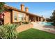 Home's backyard features a pool, grassy area, and covered patio at 12605 E Kalil Dr, Scottsdale, AZ 85259