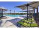 Community pool with lounge chairs and shade umbrellas at 13143 N 145Th Ln, Surprise, AZ 85379