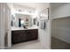 Modern bathroom with double vanity, large mirror, and walk-in closet at 13171 N 145Th Ln, Surprise, AZ 85379