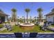 Round fire pit surrounded by grey chairs, string lights and palm trees at 13183 N 145Th Ln, Surprise, AZ 85379