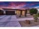 Single-story home with a two-car garage, landscaping, and a dramatic sunset at 14114 W Smoketree Dr, Surprise, AZ 85387