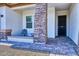 Covered front porch with brick columns and a sitting area at 14114 W Smoketree Dr, Surprise, AZ 85387