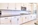 Modern kitchen with white cabinets and hexagon tile backsplash at 14114 W Smoketree Dr, Surprise, AZ 85387