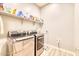 Modern laundry room with washer, dryer, and shelving at 14114 W Smoketree Dr, Surprise, AZ 85387