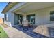 Covered patio with table and chairs, adjacent to grass at 14114 W Smoketree Dr, Surprise, AZ 85387