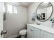 Clean bathroom with white vanity, toilet, and round mirror at 1531 W Colter St # 7, Phoenix, AZ 85015