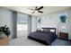 Bright main bedroom with a ceiling fan and large window at 18070 W Cielo Grande Ave, Surprise, AZ 85387