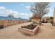 Landscaped backyard with a painted wall, raised garden beds, and firepit at 18109 W Juniper Dr, Goodyear, AZ 85338