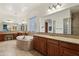 Elegant bathroom with a large soaking tub, double vanity, and glass block window at 18109 W Juniper Dr, Goodyear, AZ 85338