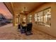 Covered patio with dining table and chairs, offering views of the living room at 18109 W Juniper Dr, Goodyear, AZ 85338