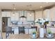 Modern kitchen with white cabinets, island, and stainless steel appliances at 18202 W Cielo Grande Ave, Surprise, AZ 85387