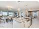 Modern kitchen with white cabinets, island, and view into dining area at 18202 W Cielo Grande Ave, Surprise, AZ 85387