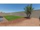 Landscaped backyard with artificial turf and block wall at 18972 W Woodlands Ave, Buckeye, AZ 85326