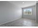 Simple bedroom with tile flooring and a window at 18972 W Woodlands Ave, Buckeye, AZ 85326