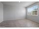 Simple bedroom with large window and tile floors at 18972 W Woodlands Ave, Buckeye, AZ 85326