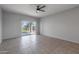 Bedroom with tile flooring, ceiling fan, and sliding glass door to backyard at 18972 W Woodlands Ave, Buckeye, AZ 85326