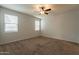 Spacious bedroom with two windows and ceiling fan at 18972 W Woodlands Ave, Buckeye, AZ 85326