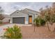 Gray house with a two-car garage and landscaping at 18972 W Woodlands Ave, Buckeye, AZ 85326