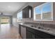 Kitchen with double sink, granite counters, and dark cabinets at 18972 W Woodlands Ave, Buckeye, AZ 85326