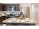 Kitchen island with granite countertop and seating for two at 18972 W Woodlands Ave, Buckeye, AZ 85326