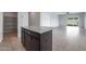 Granite kitchen island with dark wood cabinets and drawers at 18972 W Woodlands Ave, Buckeye, AZ 85326