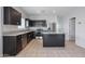 Modern kitchen with dark cabinets, granite counters, and stainless steel appliances at 18972 W Woodlands Ave, Buckeye, AZ 85326