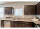 Sleek kitchen with dark cabinetry and granite countertops at 18972 W Woodlands Ave, Buckeye, AZ 85326