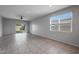 Bright living room with tile floors, sliding glass doors, and ceiling fan at 18972 W Woodlands Ave, Buckeye, AZ 85326