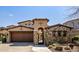 Inviting exterior with stone accents and a large wooden garage door at 19627 N 101St St, Scottsdale, AZ 85255