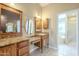 Bathroom with double vanity, wood cabinets, and a large mirror at 2124 E Virginia St, Mesa, AZ 85213